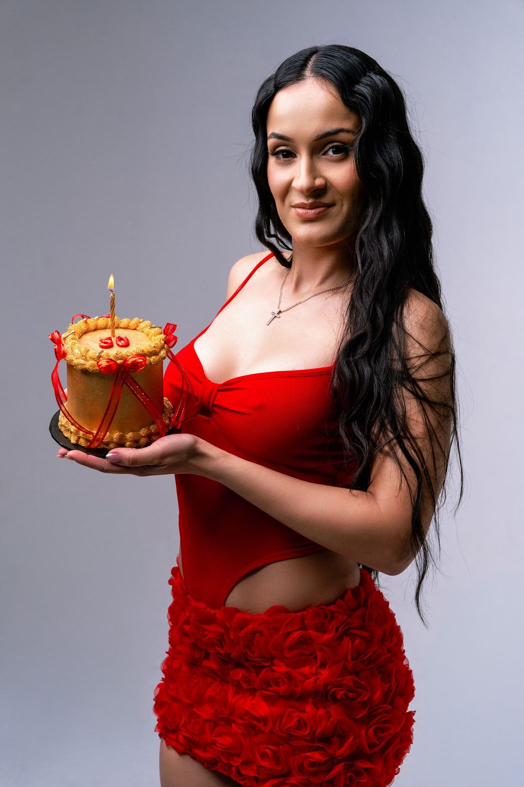 Woman in red holding a birthday cake